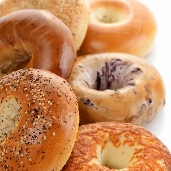 A close-up of various New York Bagel Company bagels, including sesame, poppy seed, and cheese.