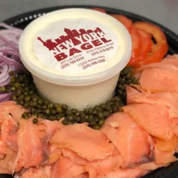 New York Bagel Company lox platter with cream cheese, capers, red onion, and sliced tomatoes.